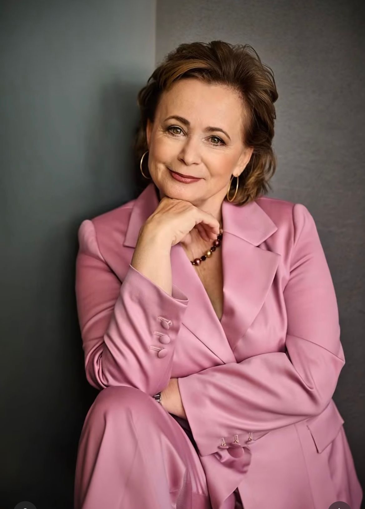 Jana Nagyová im rosafarbenen Anzug, sitzend, Porträt